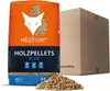 A bag of Heizfuxx Holzpellets Blue with a cardboard box in the background and some pellets scattered in the foreground. Produktbild-Vorschau