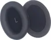 Two black ear pads for headphones are shown against a white background. One ear pad is slightly angled, and the other is lying flat. Voir les images du produit