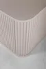 A close-up of the corner of a beige cabinet with vertical ribbed detailing. Anteprima dell’immagine prodotto