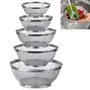 A set of five stainless steel colanders of varying sizes are stacked on top of each other against a white background. A small inset image in the upper right corner shows a hand washing cucumbers and radishes in one of the colanders in a sink. Produktbild-Vorschau