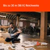 A man wearing a headset is sitting on the floor in an office environment, looking at a laptop. Papers are scattered around him. Produktbild-Vorschau