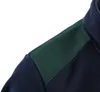 A close-up view of the shoulder and collar area of a navy blue fleece jacket with a dark green fabric overlay on the shoulder. Náhľad obrázku produktu