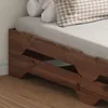 Close-up view of a wooden bed frame with bedding and pillows. Produktbild-Vorschau