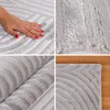 A collage of four images showing different views of a gray rug with a geometric pattern. One image shows a hand touching the rug, another shows a close-up of the rug's texture, a third shows the rug rolled up, and the fourth shows a corner of the rug on a  Náhled obrázku produktu
