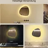 Collage of three bathroom scenes featuring an irregularly shaped mirror with LED lighting. Produktbild-Vorschau