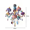 A colorful, cartoon-style chandelier with multiple arms and decorative elements. Produktbild-Vorschau