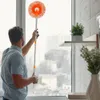 A man is cleaning a window with a mop. Náhled obrázku produktu
