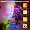 A spiral LED Christmas tree with colorful lights, placed indoors next to a larger decorated Christmas tree and gift boxes. Anteprima dell’immagine prodotto