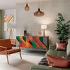 A modern living room with a colorful sideboard, armchair, and sofa. Anteprima dell’immagine prodotto