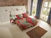 A bedroom scene with a pallet bed, colorful bedding, and decorative elements. Produktbild-Vorschau