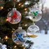 Christmas ornaments shaped like birds hanging on a decorated Christmas tree in a snowy outdoor setting. Produktbild-Vorschau