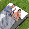 A couple sleeping on an air mattress outdoors on the grass. Náhled obrázku produktu