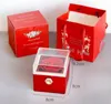 A red gift box with a preserved rose inside, next to a red gift bag and another red box. Anteprima dell’immagine prodotto