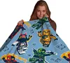 A woman is holding up a blanket with a Lego Ninjago pattern. Anteprima dell’immagine prodotto