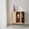 A wooden cabinet with a rattan front door, displaying decorative vases and bottles. Anteprima dell’immagine prodotto