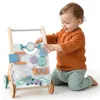 A baby is playing with a wooden walker. Produktbild-Vorschau