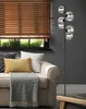 A floor lamp with multiple glass globes is positioned next to a sofa with decorative pillows and a throw blanket. Voir les images du produit