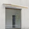 A beige awning is extended over a large glass window on a concrete wall. Anteprima dell’immagine prodotto