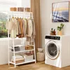 A white garment rack with clothes and storage shelves is placed next to a washing machine in a room with a window and curtains. Anteprima dell’immagine prodotto