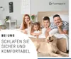 A family and their dog are lying on a bed in a bedroom. Produktbild-Vorschau