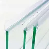 Close-up view of three transparent shower door seals attached to glass panels. Podgląd zdjęcia produktu