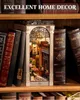 A miniature book nook diorama of a street scene is placed between two stacks of books on a wooden shelf. Podgląd zdjęcia produktu