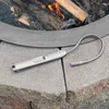 A Zippo Flex Neck Utility XL lighter is placed on stone pavers next to a fire pit with burning wood. Anteprima dell’immagine prodotto