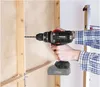 A person is using a cordless drill to drill a hole in a wooden wall. Produktbild-Vorschau