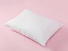 A white pillow is placed diagonally on a pink background. Produktbild-Vorschau