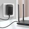 A black power adapter plugged into a white wall socket, connected by a black cable to a black router with two antennas. Voir les images du produit