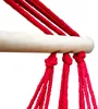 Close-up of red ropes tied to a wooden bar, likely part of a hammock or swing. Náhled obrázku produktu