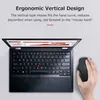 A hand is using a black vertical mouse next to an open laptop. Voir les images du produit