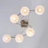 A modern ceiling light fixture with six frosted glass globes arranged in a swirling pattern, mounted on a brushed metal base. Produktbild-Vorschau