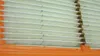 Close-up view of pleated air filter material with an orange plastic frame. Voir les images du produit