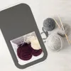 Balls of yarn and knitting needles are arranged next to a gray storage container filled with yarn. Podgląd zdjęcia produktu