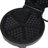 A close-up view of an open black waffle maker with heart-shaped molds. Produktbild-Vorschau