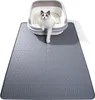 A cat is sitting in a litter box on top of a gray litter mat. Produktbild-Vorschau