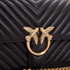 A close-up shot of a black quilted handbag with gold bird-shaped hardware. Voir les images du produit