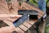A person is charging a smartphone using a portable power bank on a wooden table outdoors. Anteprima dell’immagine prodotto