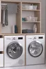A laundry room setup with two washing machines and a cabinet. Produktbild-Vorschau