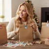 A woman is preparing an advent calendar with gift bags and stickers. Produktbild-Vorschau