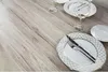 A table setting with plates and wine glasses on a wooden table. Podgląd zdjęcia produktu