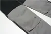 A close-up view of a pair of work pants with black and gray panels and pockets. Produktbild-Vorschau