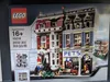 The image shows the front of a Lego 10218 Pet Shop building set box. The box displays a detailed image of the assembled Lego model, which features two connected buildings: a pet shop and an apartment. Several Lego minifigures and accessories are also visib Náhled obrázku produktu