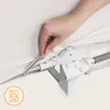 A hand is shown adjusting the fabric of a beige bed rail, highlighting a zipper mechanism. A washing machine icon is visible in the bottom left corner. Voir les images du produit