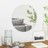 A round mirror reflecting a sofa and plants, placed on a wall above a table with decorative items. Náhľad obrázku produktu