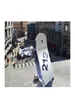 A perfume bottle with '212' printed on it is placed on a ledge overlooking a city street with people and cars. Náhľad obrázku produktu