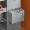 A close-up view of a gray kitchen cart with a drawer pulled out, revealing several clear glasses with gold rims. Produktbild-Vorschau