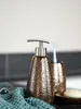 A close-up shot of a soap dispenser and toothbrush holder on a countertop. Náhľad obrázku produktu