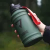 A hand holding a green water bottle outdoors. Anteprima dell’immagine prodotto